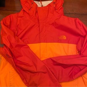 The north face Rain coat in bright orange used condition
